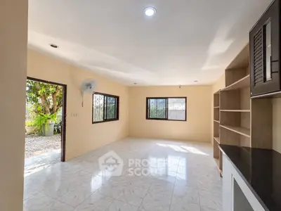 Spacious living room with large windows and garden view, perfect for natural light and open living.
