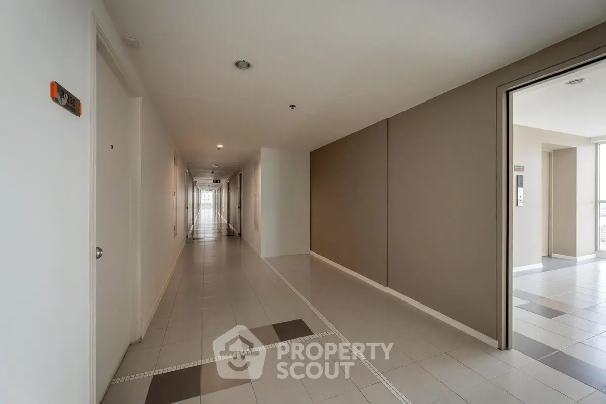 Modern apartment hallway with sleek tile flooring and neutral walls
