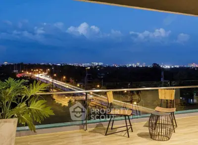 Stunning balcony view with modern seating overlooking city skyline at dusk.