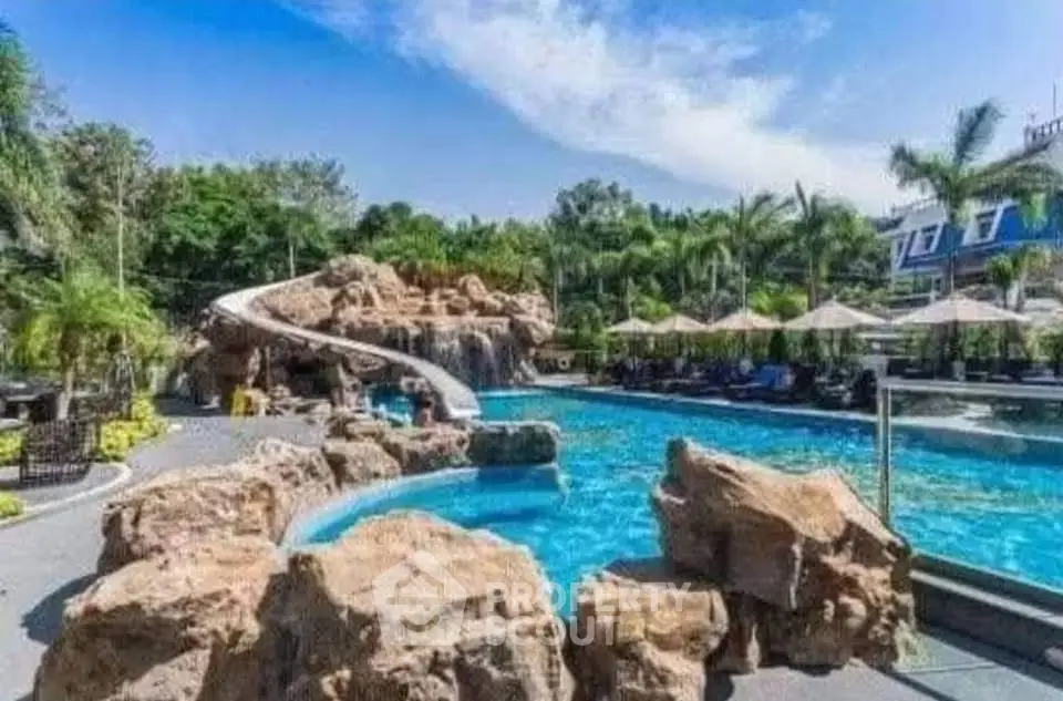 Luxurious resort-style pool with water slide and lush landscaping