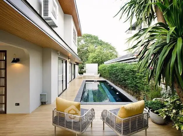 Luxurious modern home with private pool and stylish outdoor seating area, perfect for relaxation.