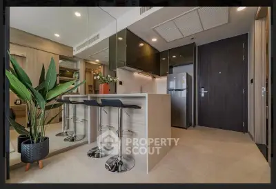 Modern kitchen with sleek design, featuring a breakfast bar and stainless steel appliances.