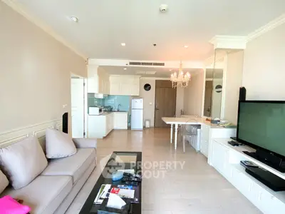 Spacious living room with elegant decor and open kitchen layout, featuring modern appliances and a cozy seating area.