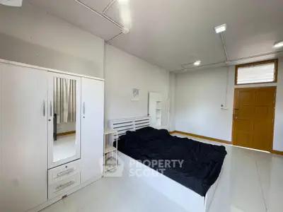 Spacious bedroom with modern white furniture and natural light