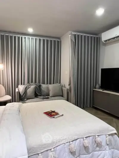 Cozy bedroom with modern decor, featuring a comfortable bed, stylish curtains, and a wall-mounted TV.