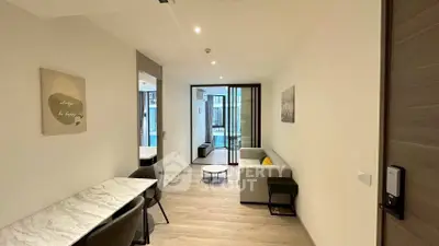 Modern living room with sleek furniture and open layout, featuring a cozy sofa and stylish dining area.