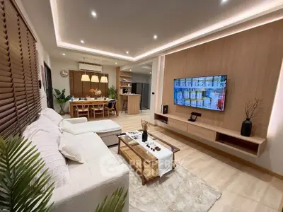 Modern living room with cozy seating, stylish decor, and open kitchen layout, perfect for contemporary living.