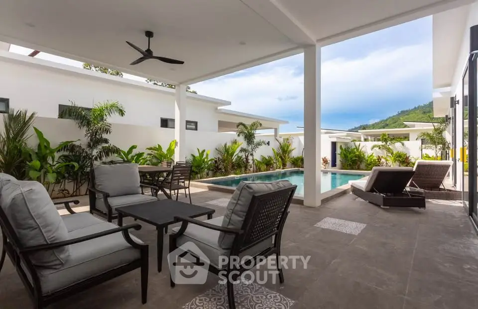 Luxurious outdoor patio with pool and lush greenery, perfect for relaxation and entertaining.