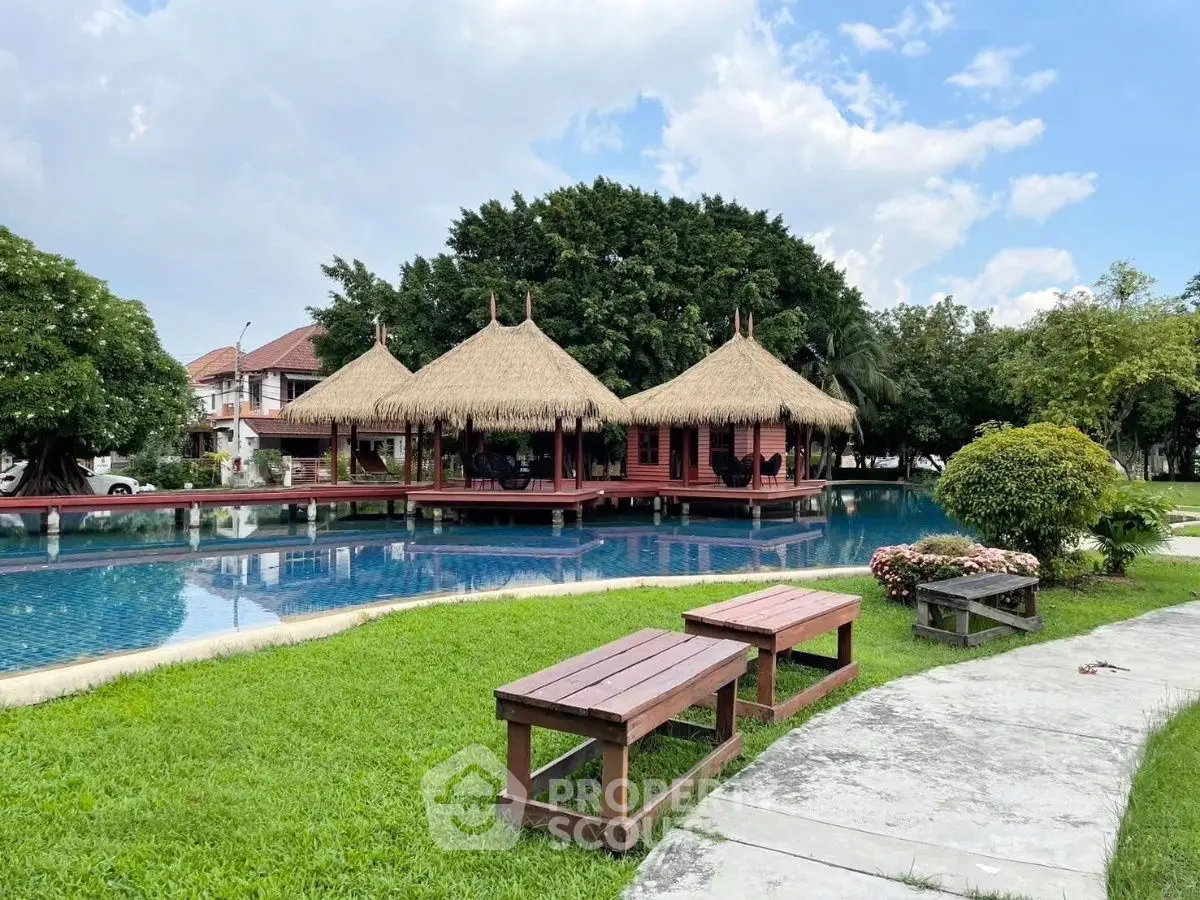 Luxurious tropical poolside retreat with traditional thatched-roof pavilions and lush greenery.