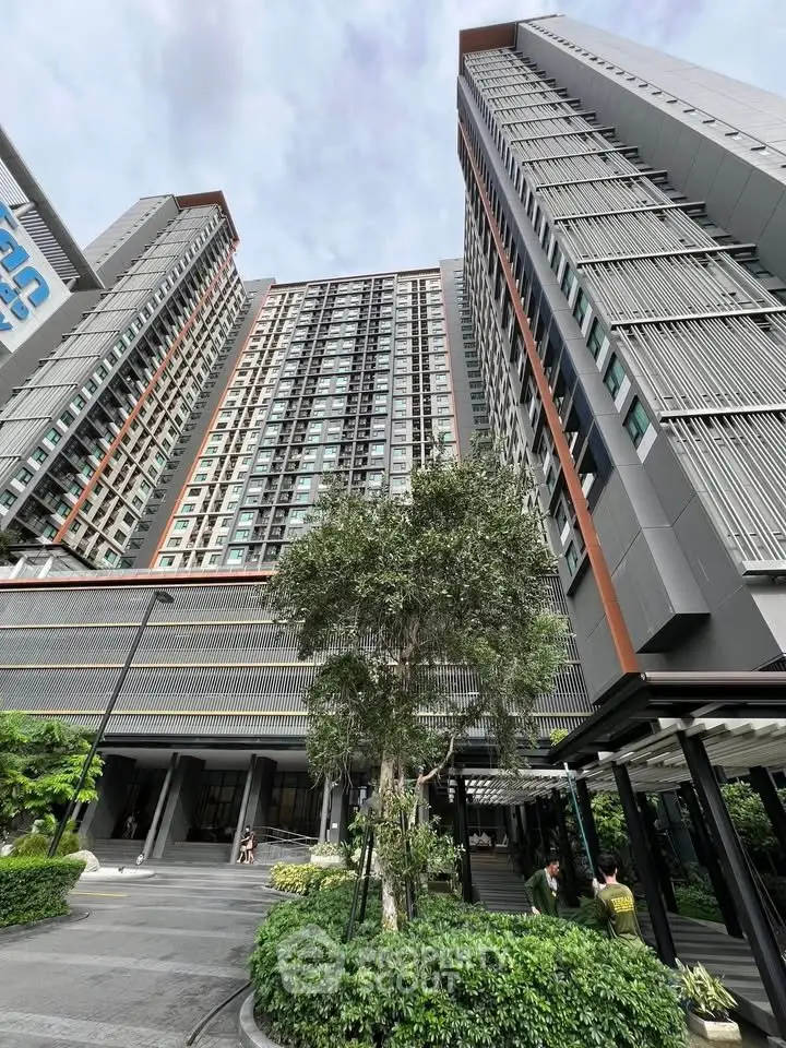 Modern high-rise building with sleek design and lush landscaping