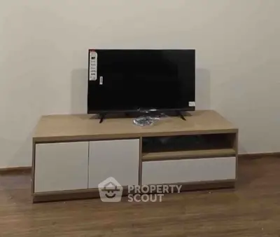 Modern living room setup with sleek TV stand and flat-screen television on wooden flooring.