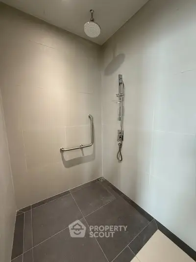 Modern bathroom with sleek shower and safety handrail in contemporary design.