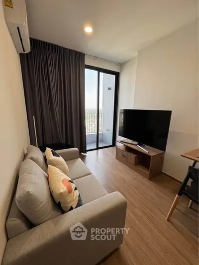 Modern living room with cozy sofa and large TV, featuring a balcony view.