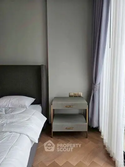 Modern bedroom with stylish side table and floor-to-ceiling curtains