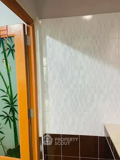 Modern bathroom with stylish tile design and wooden door accent
