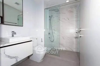 Modern bathroom with sleek design, featuring a glass shower and elegant marble finishes.