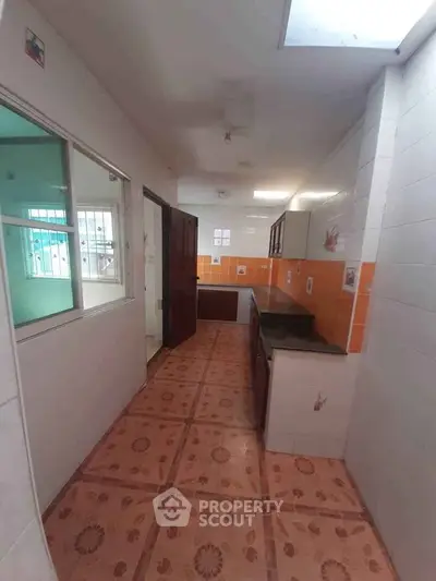 Charming kitchen with vibrant orange tiles and ample counter space