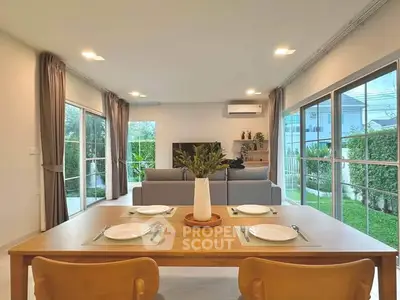 Spacious living room with garden view, modern decor, and ample natural light.