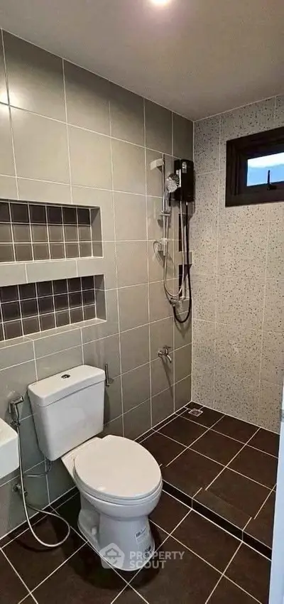 Modern bathroom with sleek tiles and shower area in contemporary home.