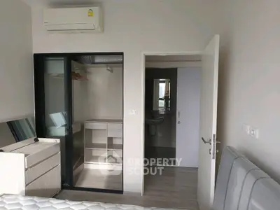 Modern bedroom with walk-in closet and bathroom access, featuring sleek design and ample storage.