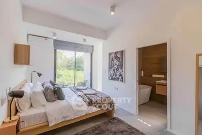 Modern bedroom with ensuite bathroom and large window offering scenic views.
