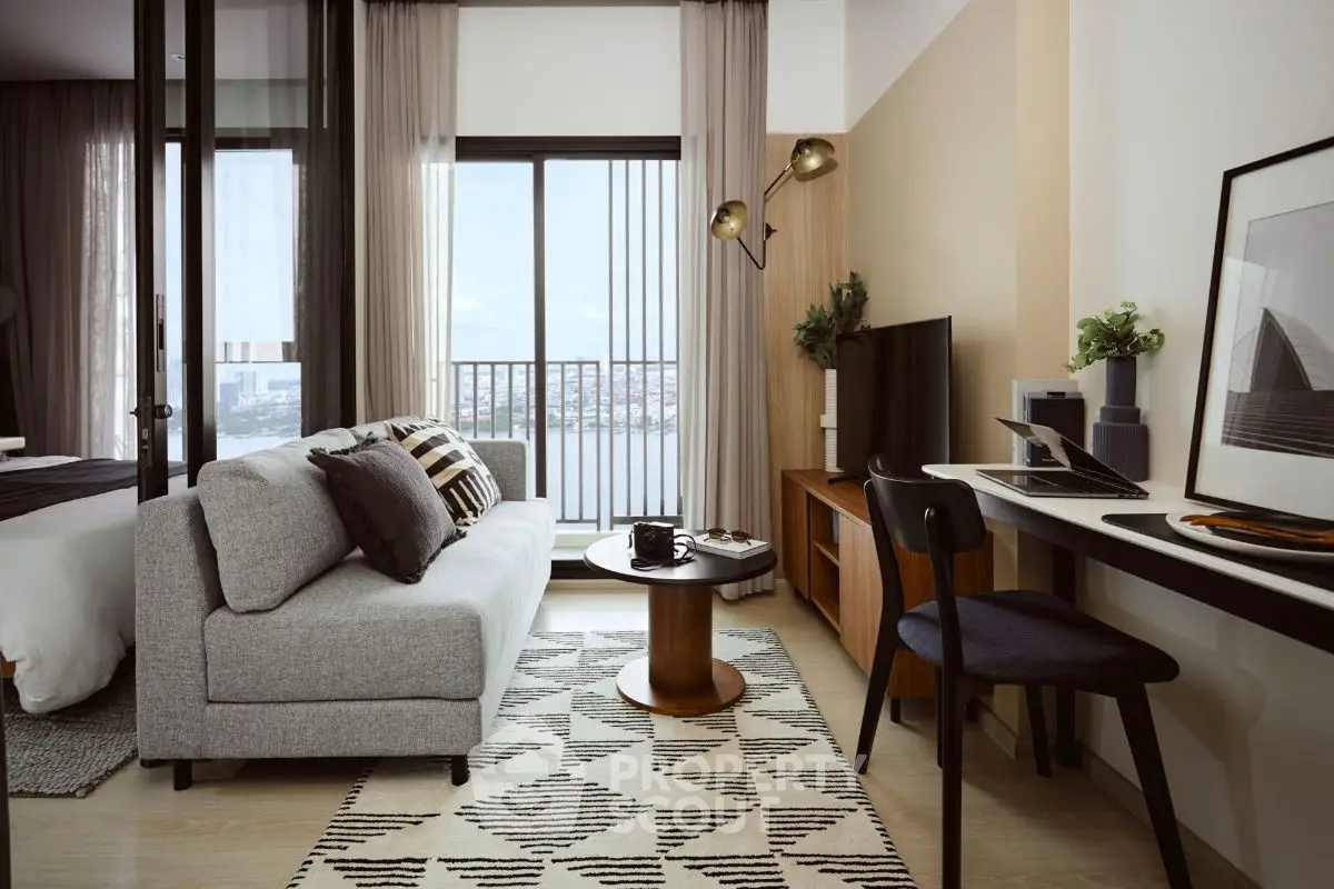 Modern living room with stylish decor and balcony view in a high-rise apartment.