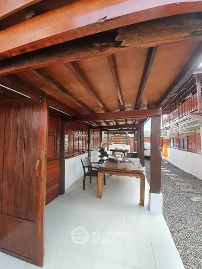 Charming rustic wooden patio with outdoor seating and natural stone flooring.
