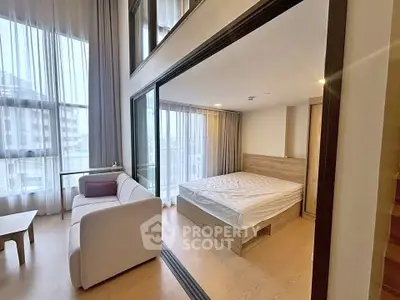 Modern studio apartment with large windows and stylish furnishings
