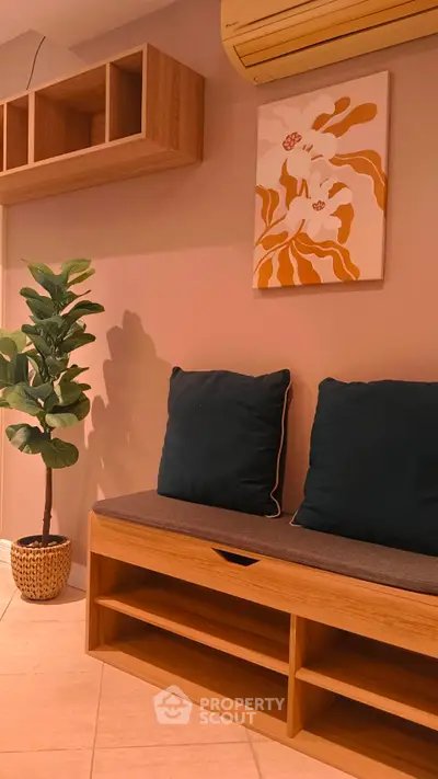 Cozy interior with stylish bench, cushions, and wall art in a modern living space.