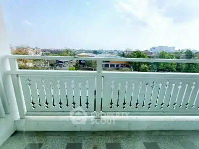 Spacious balcony with scenic view of cityscape and greenery, perfect for relaxation.