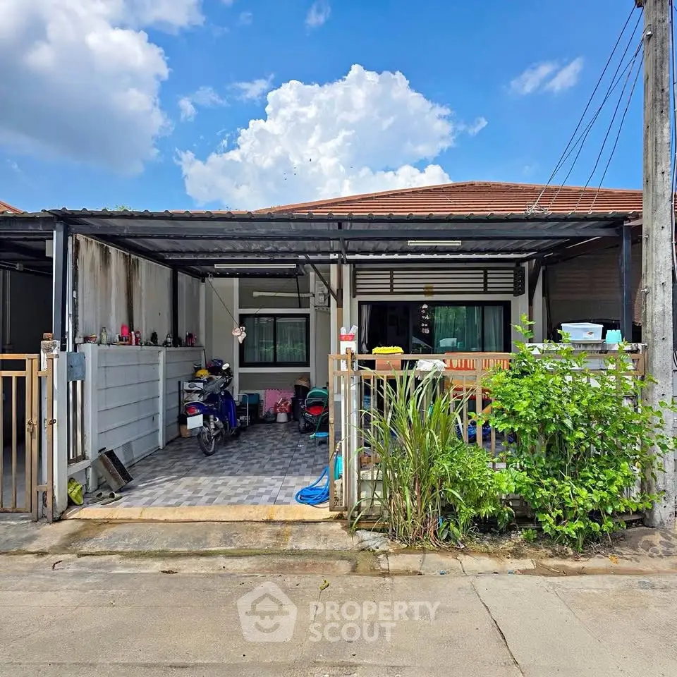 Charming single-story home with a covered carport and lush greenery, perfect for cozy living.