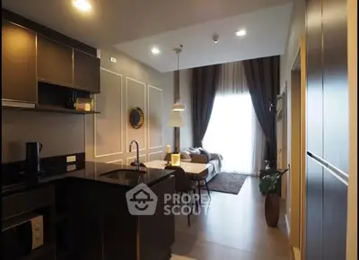 Modern open-layout kitchen and living area with stylish decor and natural light.