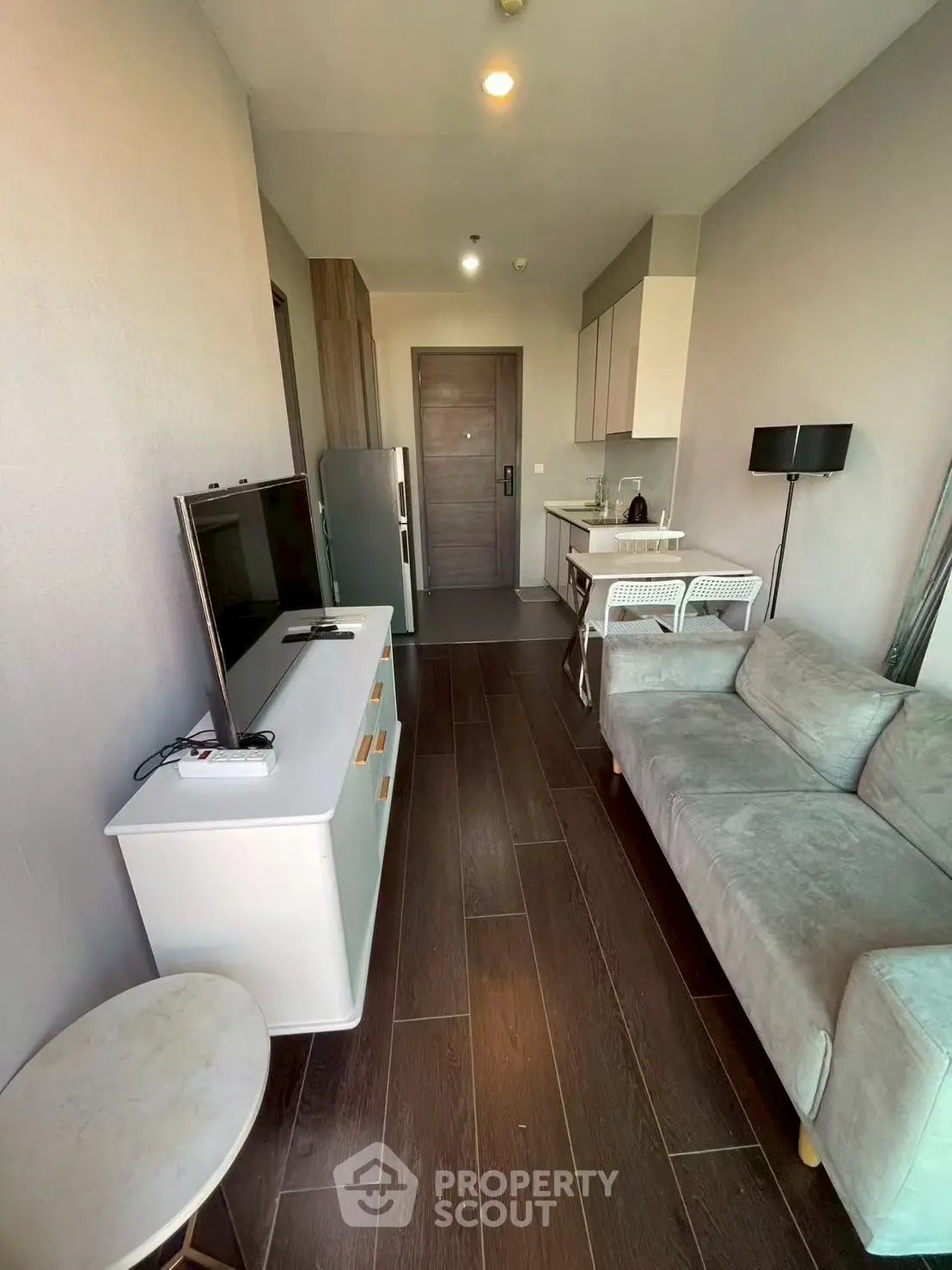 Modern living room with sleek furniture and open kitchen layout in a stylish apartment.