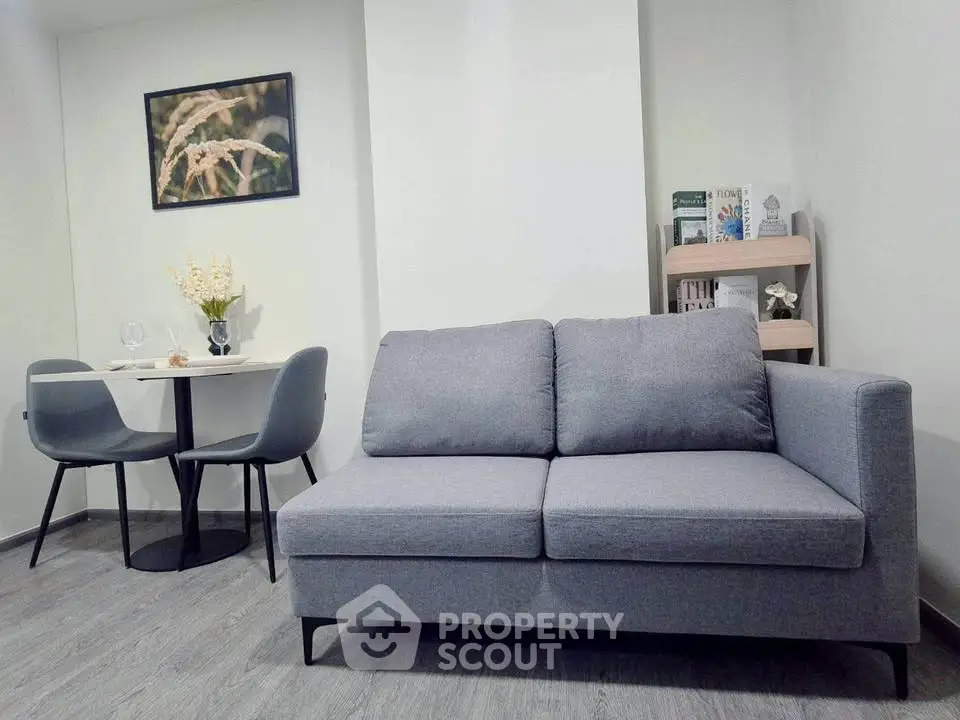 Modern living room with stylish gray sofa and cozy dining area, perfect for urban living.