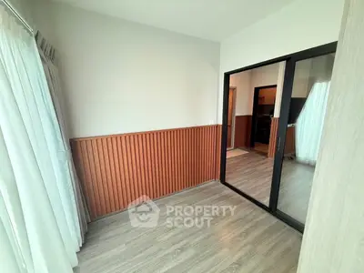 Bright room with wooden paneling and mirrored sliding door