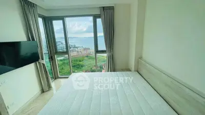 Stunning bedroom with panoramic ocean view and large windows in modern apartment.