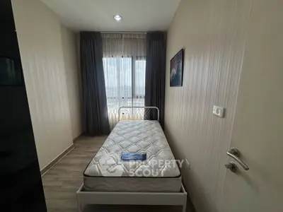 Cozy minimalist bedroom with single bed and large window offering natural light.