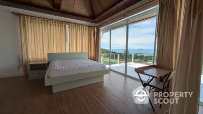 Spacious bedroom with stunning ocean view and large windows for natural light.