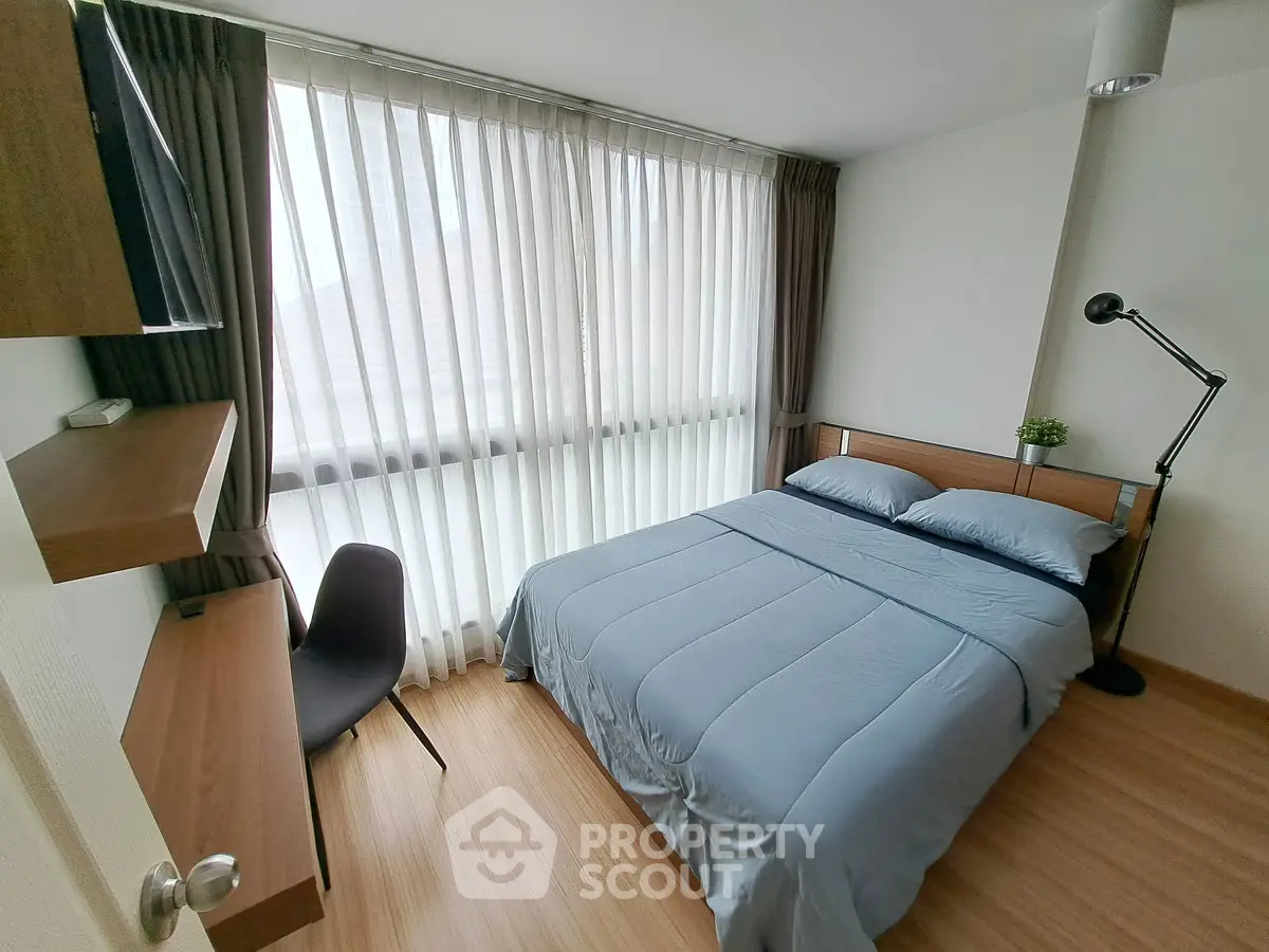 Cozy bedroom with modern furnishings and large window for natural light