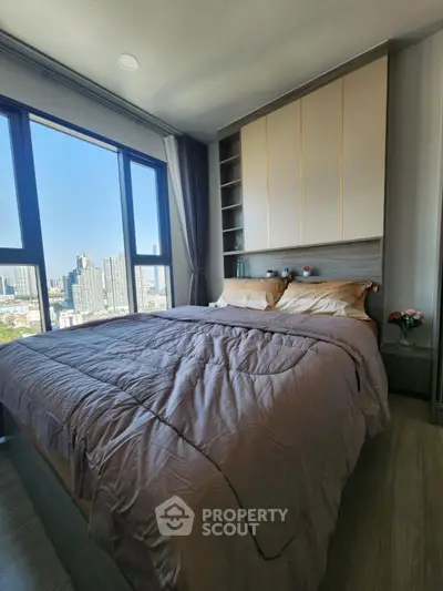 Modern bedroom with large windows offering stunning city views