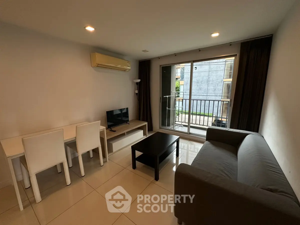 Modern living room with sleek furniture and balcony access