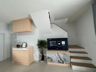 Modern living room with sleek staircase and stylish TV console