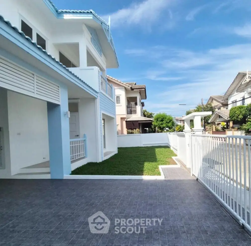 Stunning modern house with spacious driveway and lush green lawn in a serene neighborhood.