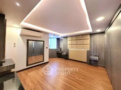 Spacious modern living room with wooden flooring and stylish ceiling lights