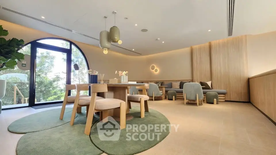 Modern living room with stylish furniture and large window offering natural light and garden view.