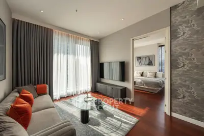 Modern living room with stylish decor and natural light, featuring a cozy sofa and sleek TV setup.