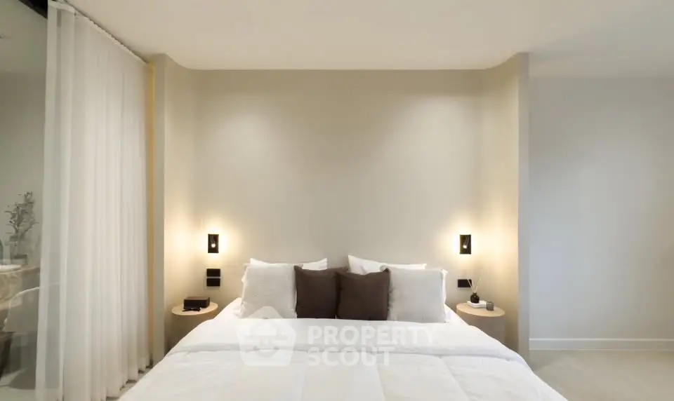 Modern bedroom with elegant lighting and neutral decor, perfect for relaxation and comfort.