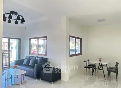 Modern living room with sleek furniture and large windows in a bright, airy space.