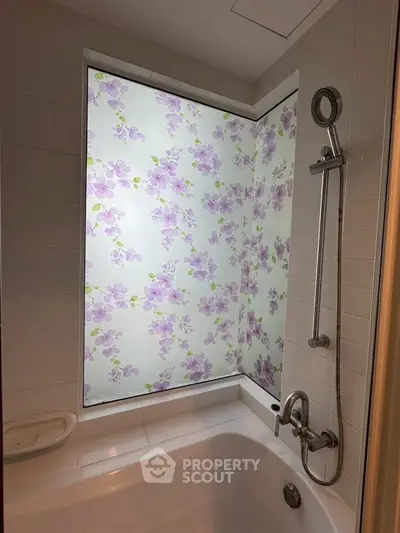 Charming bathroom with floral shower curtain and modern fixtures.