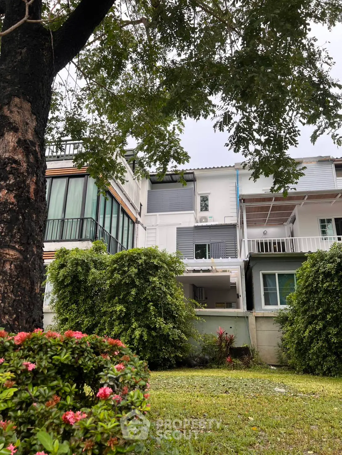 Charming townhouse with lush garden and modern facade, perfect for family living.